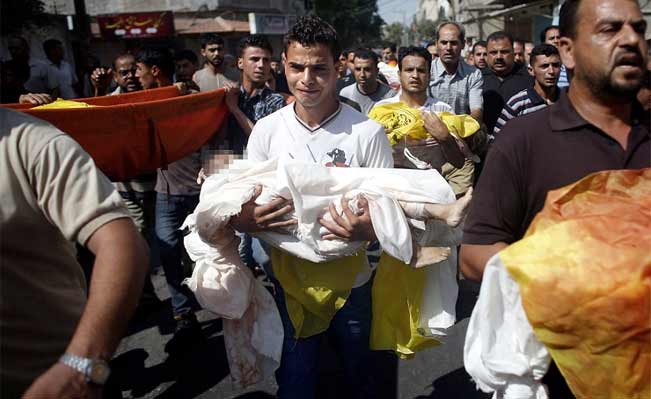 A Palestinian relative of the eight members of a family killed in an airstrike cries as he carries the body of a baby. Photograph: AFP / Getty