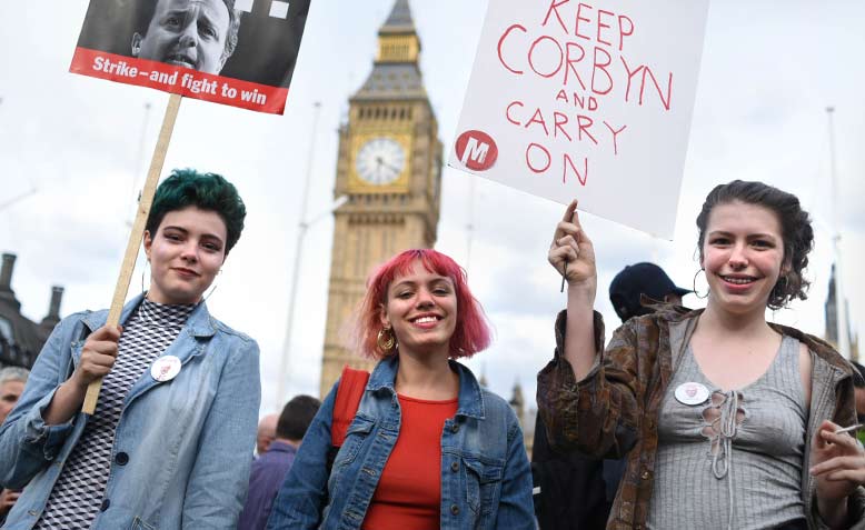 Three young women with placards in front of Big Ben, Defend Corbyn Rally, Parliament Square, London, 27 June 2016.  Photo: Jim Aindow/Flickr