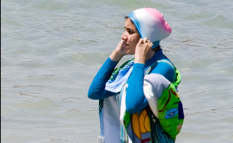 A woman wears a burkini on the beach. Photo: Wikipedia