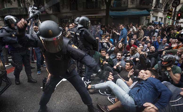 Police officers hitting protestors organised in passive resistance in Barcelona during the independence referendum of 2017. Photo: Wikipedia