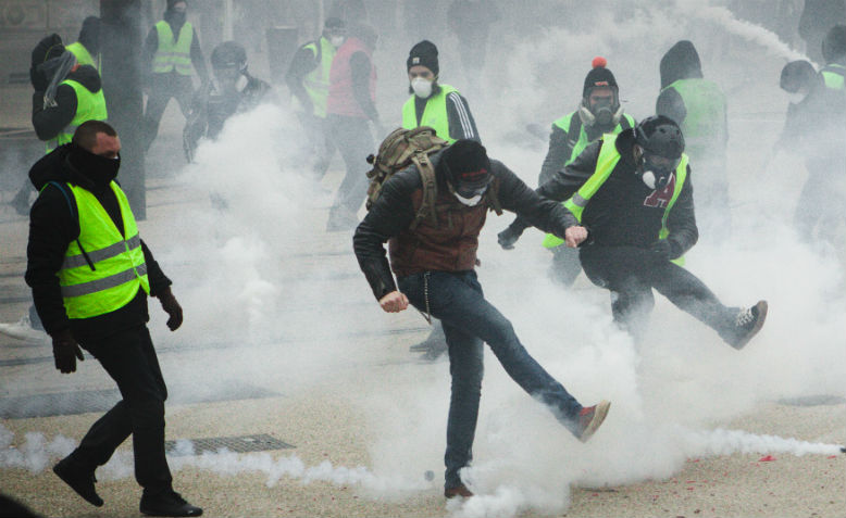 Yellow Vests kick away tear gas canisters. Photo: wikimedia commons