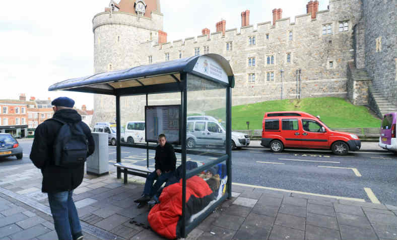 Homeless person in bus shelter next to Windsor Castle. Photo: Amer Ghazzal/Barcroft Images