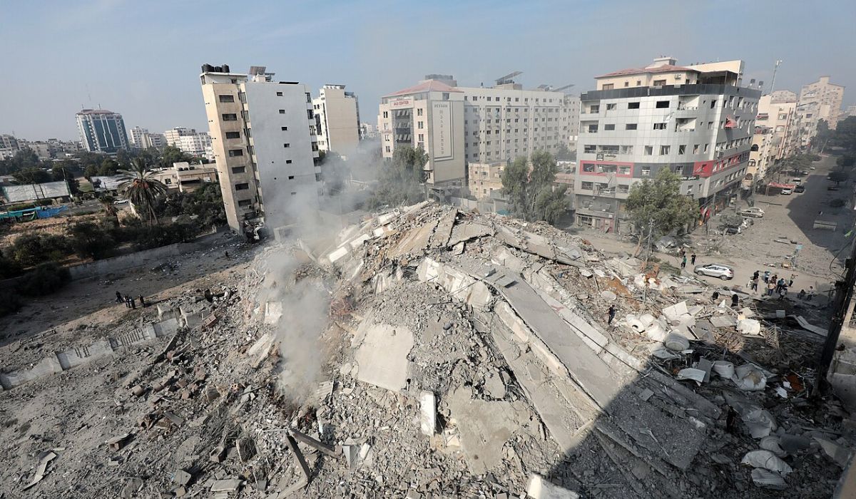 Palestinians inspect the ruins of Watan Tower destroyed in Israeli airstrikes