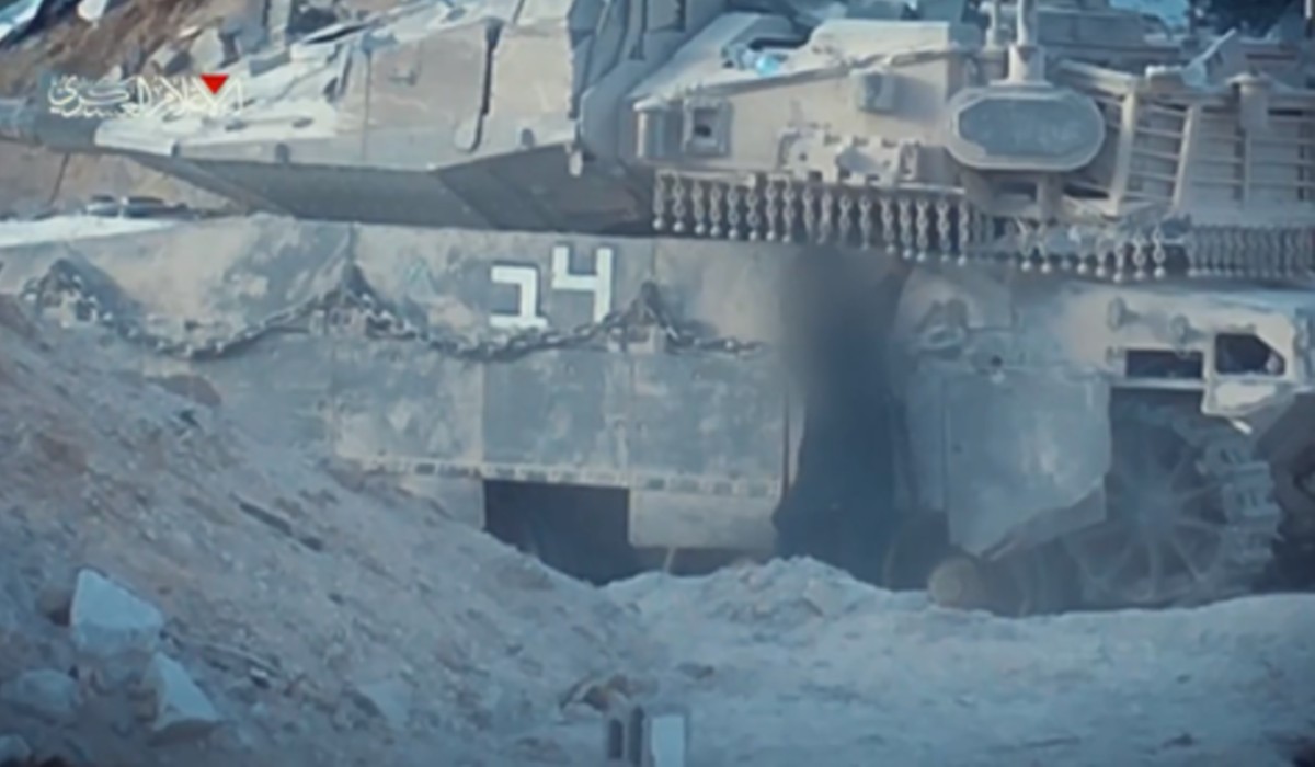 A Palestinian fighter places an explosive device under the turret of an Israeli Mekava 4 tank, Gaza City, September 2025